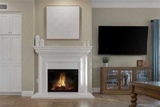 room details with baseboards, visible vents, and a glass covered fireplace