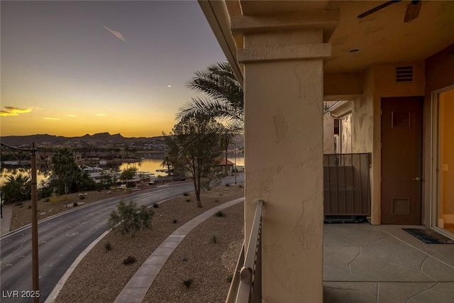 balcony at dusk featuring visible vents