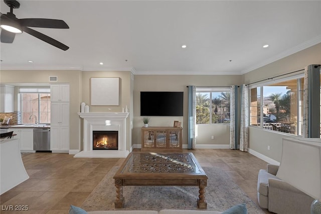 living room with light tile patterned flooring, visible vents, baseboards, a glass covered fireplace, and crown molding