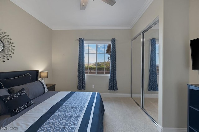 carpeted bedroom featuring ornamental molding, a closet, ceiling fan, and baseboards