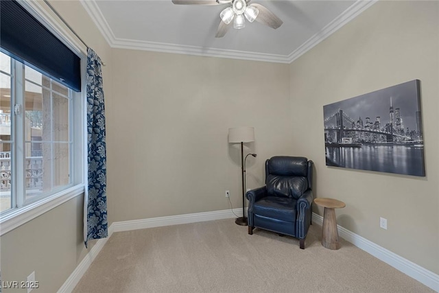 living area with ornamental molding, carpet, baseboards, and a ceiling fan