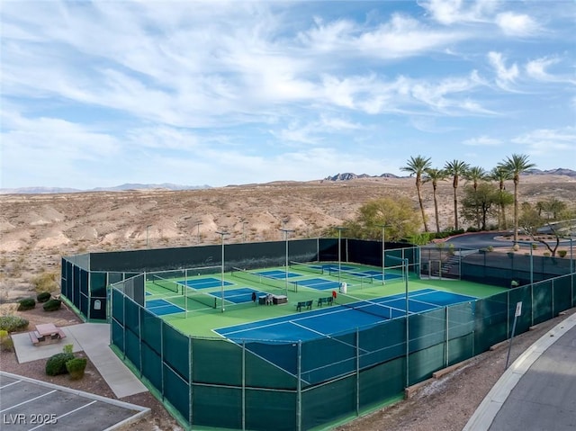 view of sport court featuring a mountain view and fence