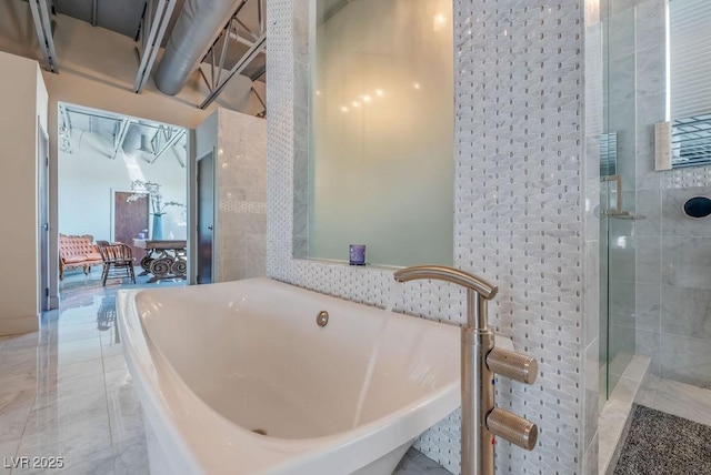 full bathroom featuring a stall shower and a freestanding tub