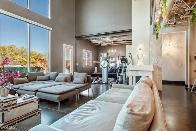 tiled living room with a high ceiling and a high end fireplace