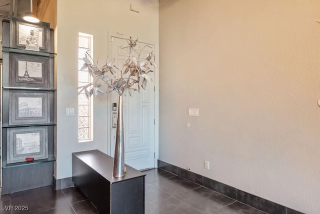 interior space featuring dark tile patterned floors and baseboards