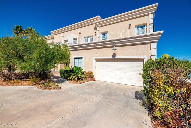 view of front of house with concrete driveway, a balcony, and stucco siding