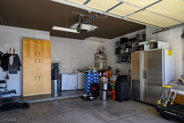 garage with stainless steel fridge and a garage door opener