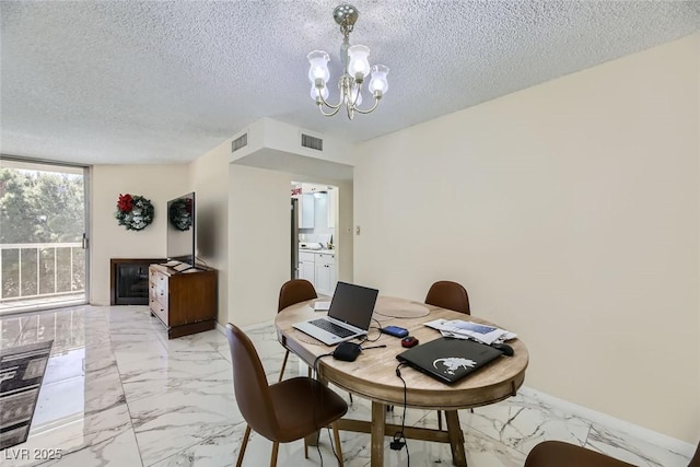 dining room with a textured ceiling, marble finish floor, visible vents, and an inviting chandelier