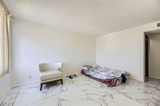 unfurnished bedroom with marble finish floor, baseboards, and a textured ceiling