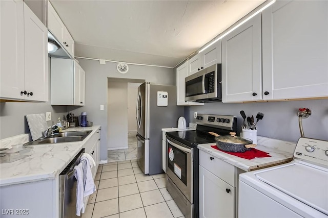 kitchen with washer / clothes dryer, marble finish floor, stainless steel appliances, white cabinetry, and a sink