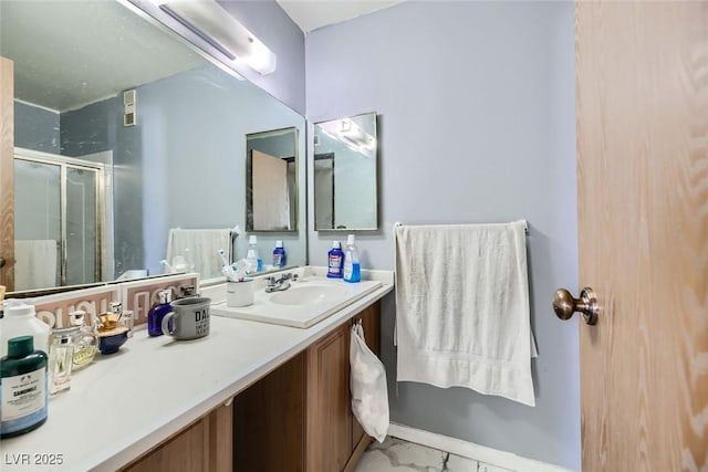 full bath featuring marble finish floor, a shower stall, and vanity