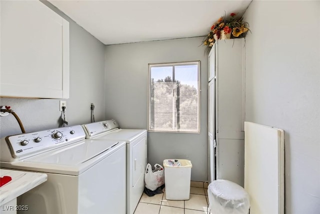 laundry room with light tile patterned floors, separate washer and dryer, and cabinet space