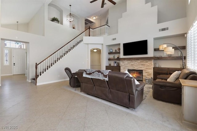 living room featuring a healthy amount of sunlight, visible vents, a fireplace, and stairs