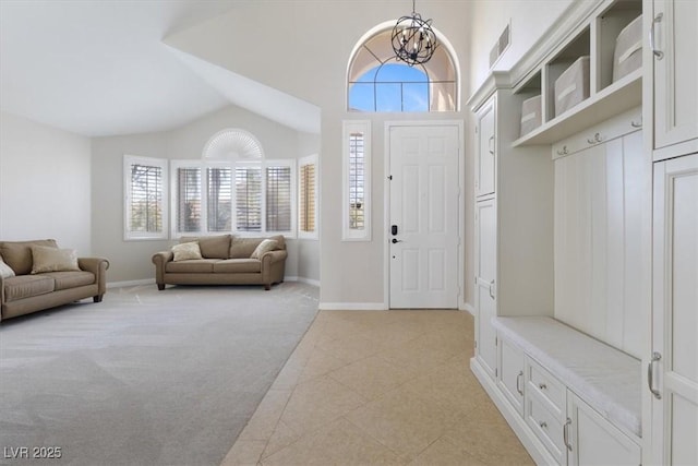 entrance foyer with light carpet, an inviting chandelier, baseboards, and visible vents