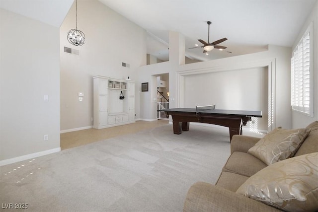 game room with light carpet, high vaulted ceiling, ceiling fan with notable chandelier, and visible vents