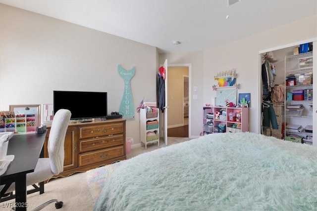 carpeted bedroom with a closet and baseboards