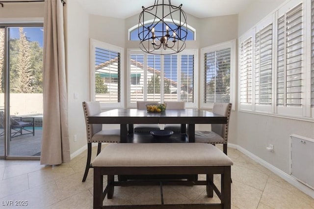 dining room featuring an inviting chandelier, baseboards, and light tile patterned flooring