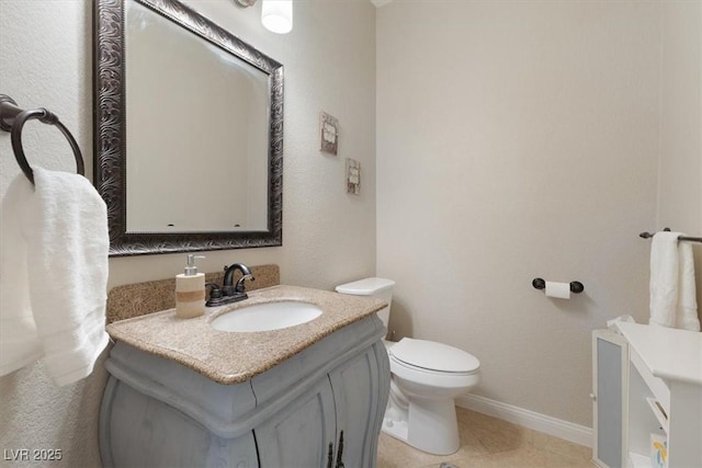 bathroom featuring baseboards, vanity, toilet, and tile patterned floors