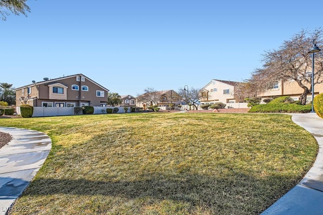 surrounding community featuring a residential view, a yard, and fence