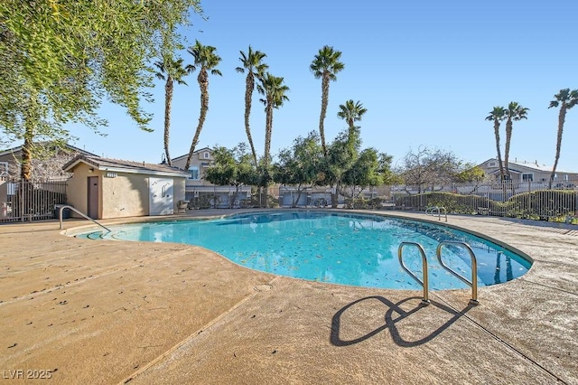 pool with a patio and fence