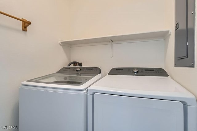 washroom featuring electric panel, laundry area, and washer and dryer