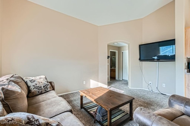 living area featuring carpet flooring, baseboards, and arched walkways