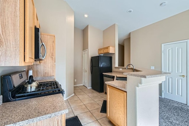 kitchen with a sink, light countertops, appliances with stainless steel finishes, and light brown cabinetry