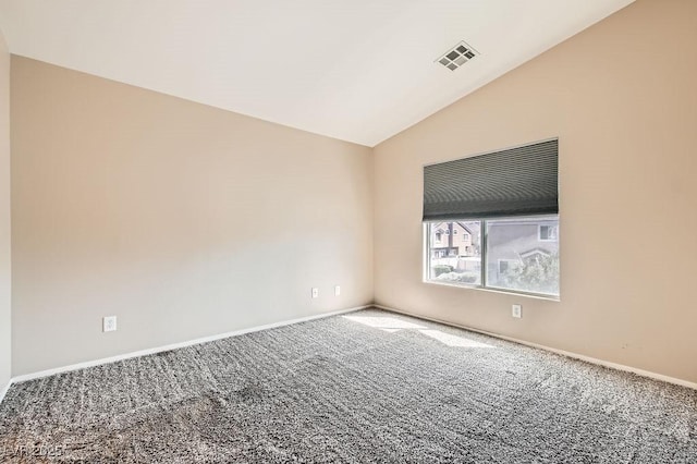 spare room with visible vents, baseboards, carpet flooring, and vaulted ceiling