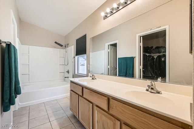 full bath featuring tile patterned flooring, vaulted ceiling, double vanity, and a sink