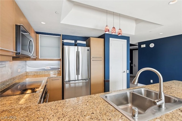 kitchen featuring light stone counters, recessed lighting, appliances with stainless steel finishes, and a sink