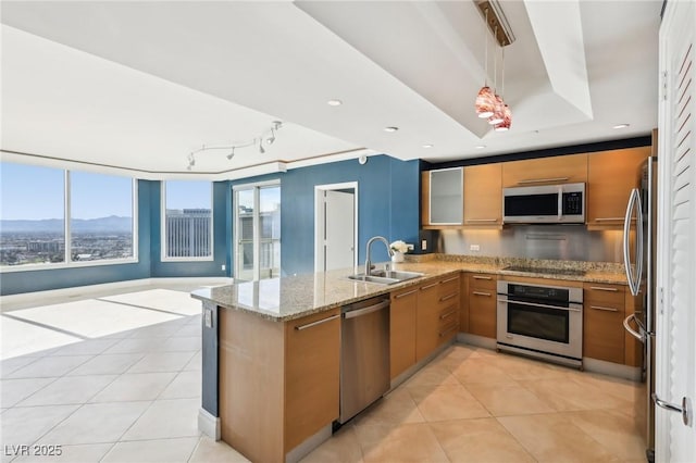 kitchen featuring light tile patterned floors, stainless steel appliances, light stone counters, and a sink