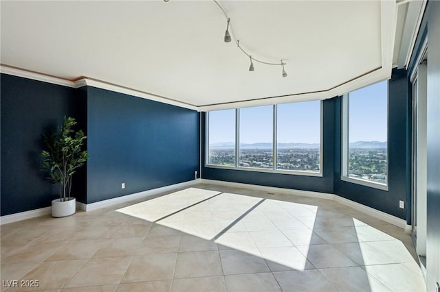 unfurnished room featuring light tile patterned floors, baseboards, ornamental molding, and track lighting