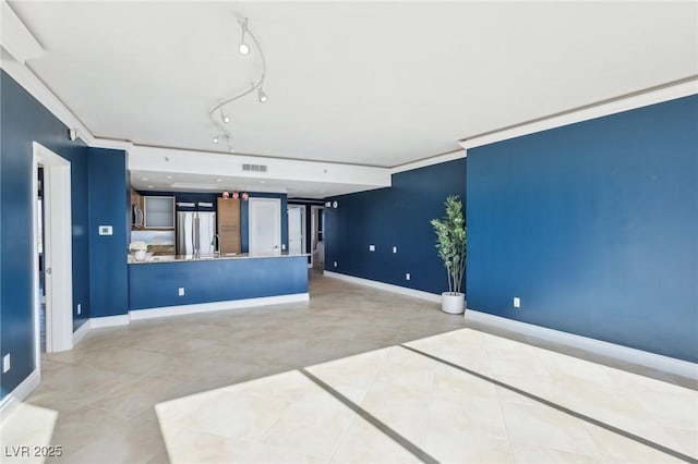 tiled spare room with visible vents, baseboards, track lighting, and crown molding