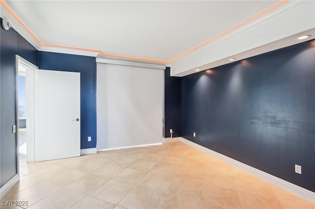 tiled empty room featuring crown molding, baseboards, and an accent wall