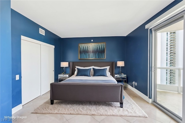 tiled bedroom featuring baseboards, visible vents, and a closet