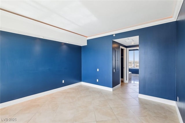 empty room featuring light tile patterned floors, baseboards, and crown molding