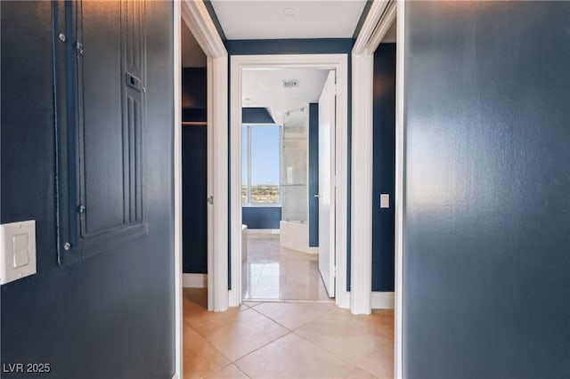 corridor with light tile patterned floors, baseboards, and visible vents