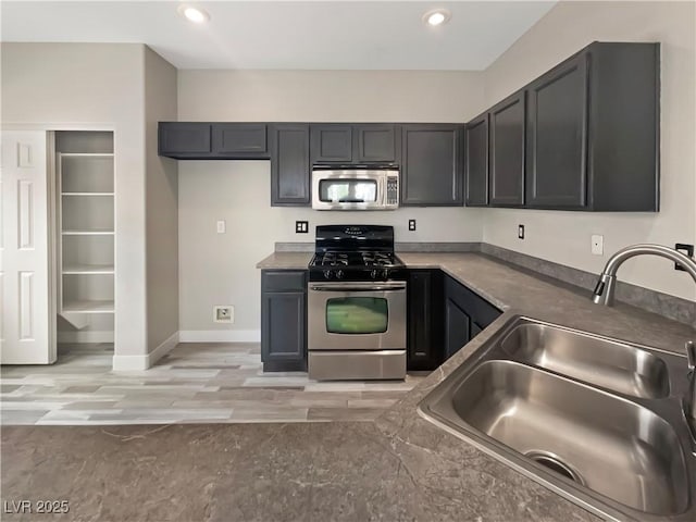 kitchen featuring light wood-style flooring, recessed lighting, stainless steel appliances, a sink, and baseboards