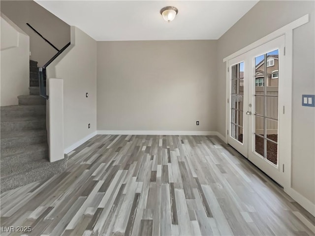 interior space with french doors, stairway, wood finished floors, and baseboards