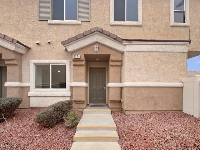 view of exterior entry featuring stucco siding