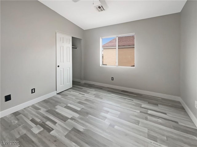 empty room featuring lofted ceiling, baseboards, visible vents, and ceiling fan