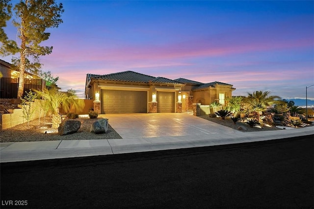 view of front of house featuring fence, driveway, stucco siding, a garage, and a tile roof