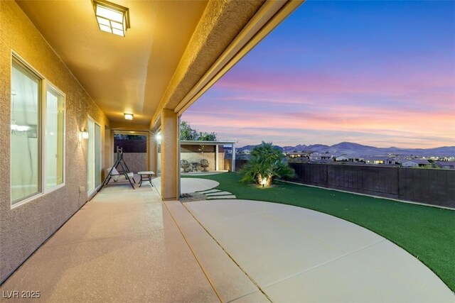 patio terrace at dusk with a fenced backyard