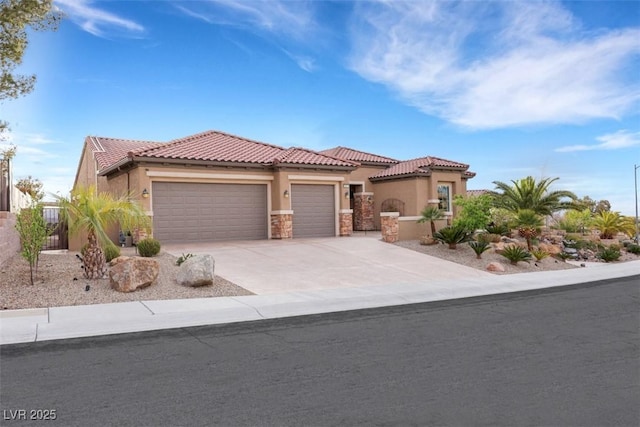 mediterranean / spanish-style house featuring stucco siding, concrete driveway, an attached garage, and a tile roof