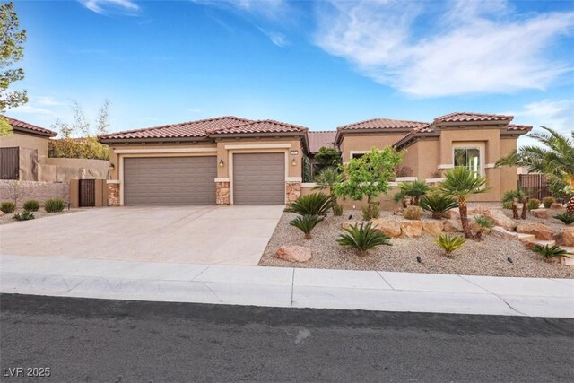 mediterranean / spanish house with fence, a tile roof, concrete driveway, stucco siding, and a garage