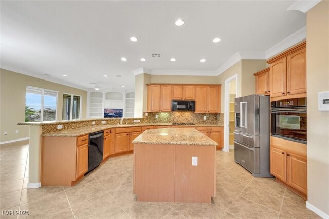 kitchen featuring light stone counters, a kitchen island, a peninsula, black appliances, and tasteful backsplash