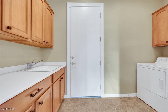 washroom featuring light tile patterned floors, baseboards, washer / dryer, cabinet space, and a sink