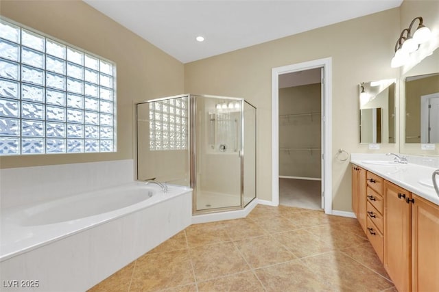 full bath featuring a sink, a shower stall, tile patterned flooring, double vanity, and a bath