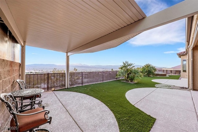 view of patio / terrace with a mountain view and a fenced backyard