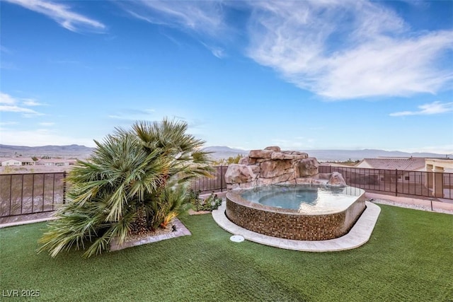 view of yard featuring a mountain view, an in ground hot tub, and a fenced backyard